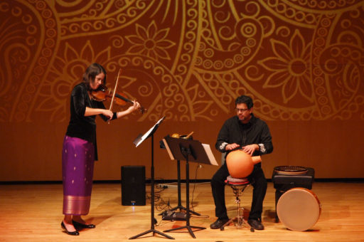 Two musicians performing on a stage.