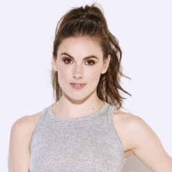 Headshot of Tiler Peck, who has brunette, long, wavy hair in a ponytail, fair skin, and standing against a white background.